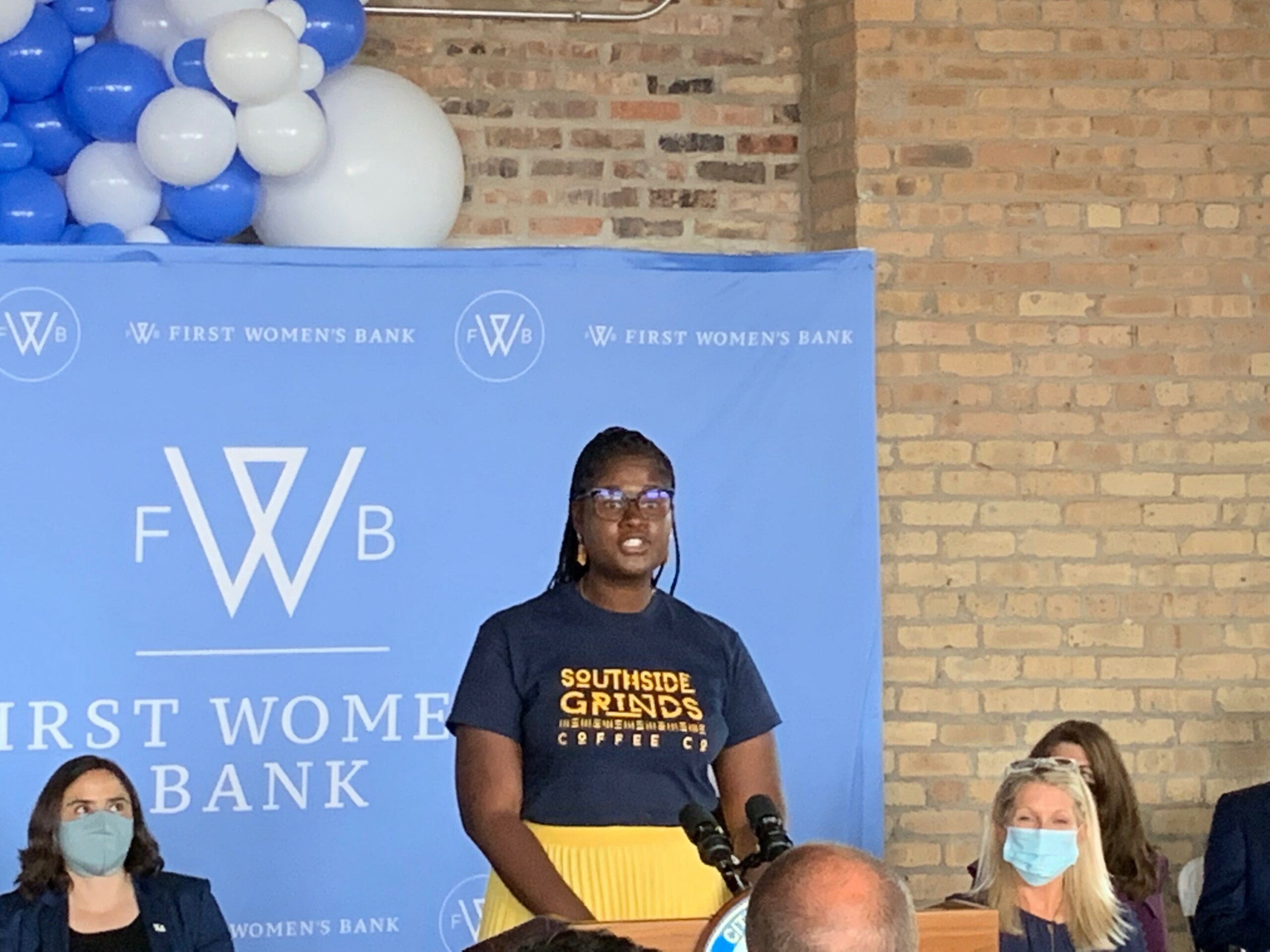 First Women's Bank event featuring speaker and an audience.